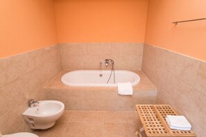 Een bad/douchecombinatie, een haardroger, een bidet, handdoeken