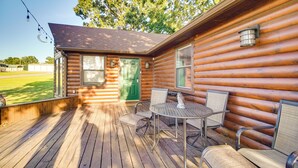 A wooden cabin with a porch, a green door, and a table with chairs. - Incredible Log Home: 1 Mile from Lake Tenkiller (Vian)