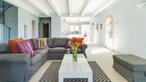 A modern living room with a grey sofa, patterned rug, and a white coffee table. - Villa Cielo - Cignella Resort Toscana (Toscana)