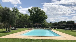 A rectangular swimming pool with a tiled deck, surrounded by a well-maintained lawn and trees. - Villa Cielo - Cignella Resort Toscana (Toscana)