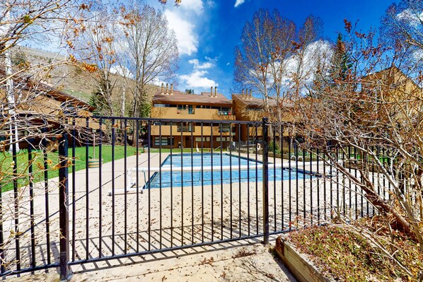Enjoy a tranquil retreat with a pool surrounded by lush greenery and a traditional home.