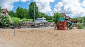 Enjoy a fun-filled day at the beach with a playground featuring a slide and climbing structures.