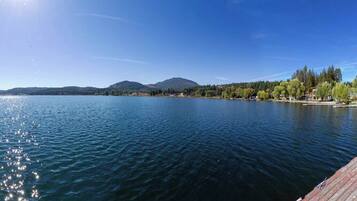 Un lago tranquillo con una montagna sullo sfondo e un molo di legno che si protende nell'acqua.