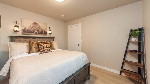 Een slaapkamer met een bed, hoofdbord, wandplank en een deur.