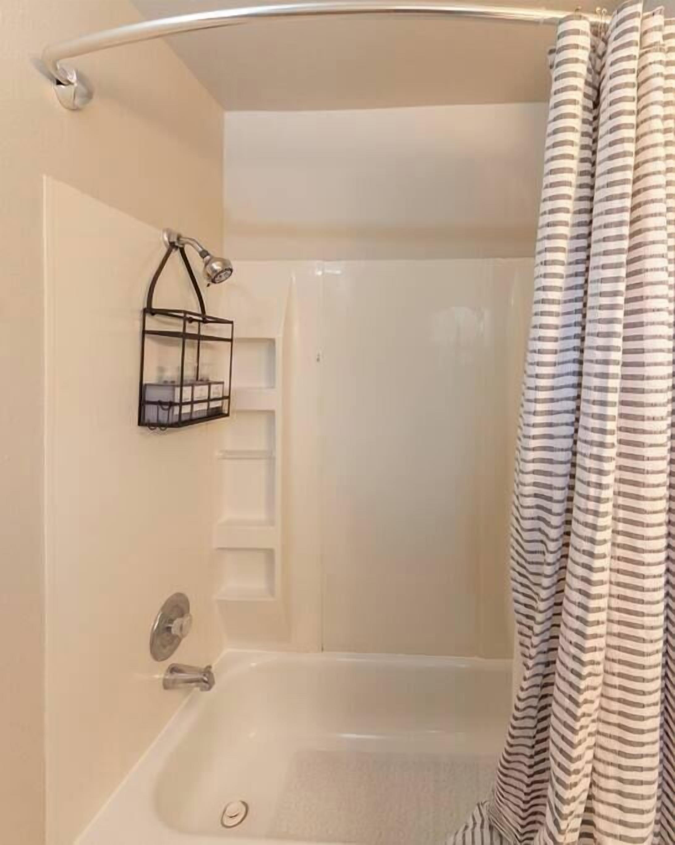 Bathtub, hair dryer, towels, shampoo