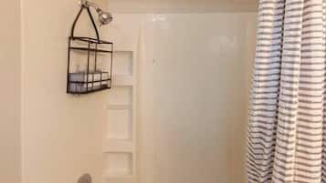 Bathtub, hair dryer, towels, shampoo