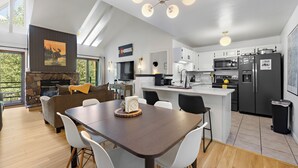 Een moderne keuken met witte kasten, een centraal eiland en een stenen open haard.