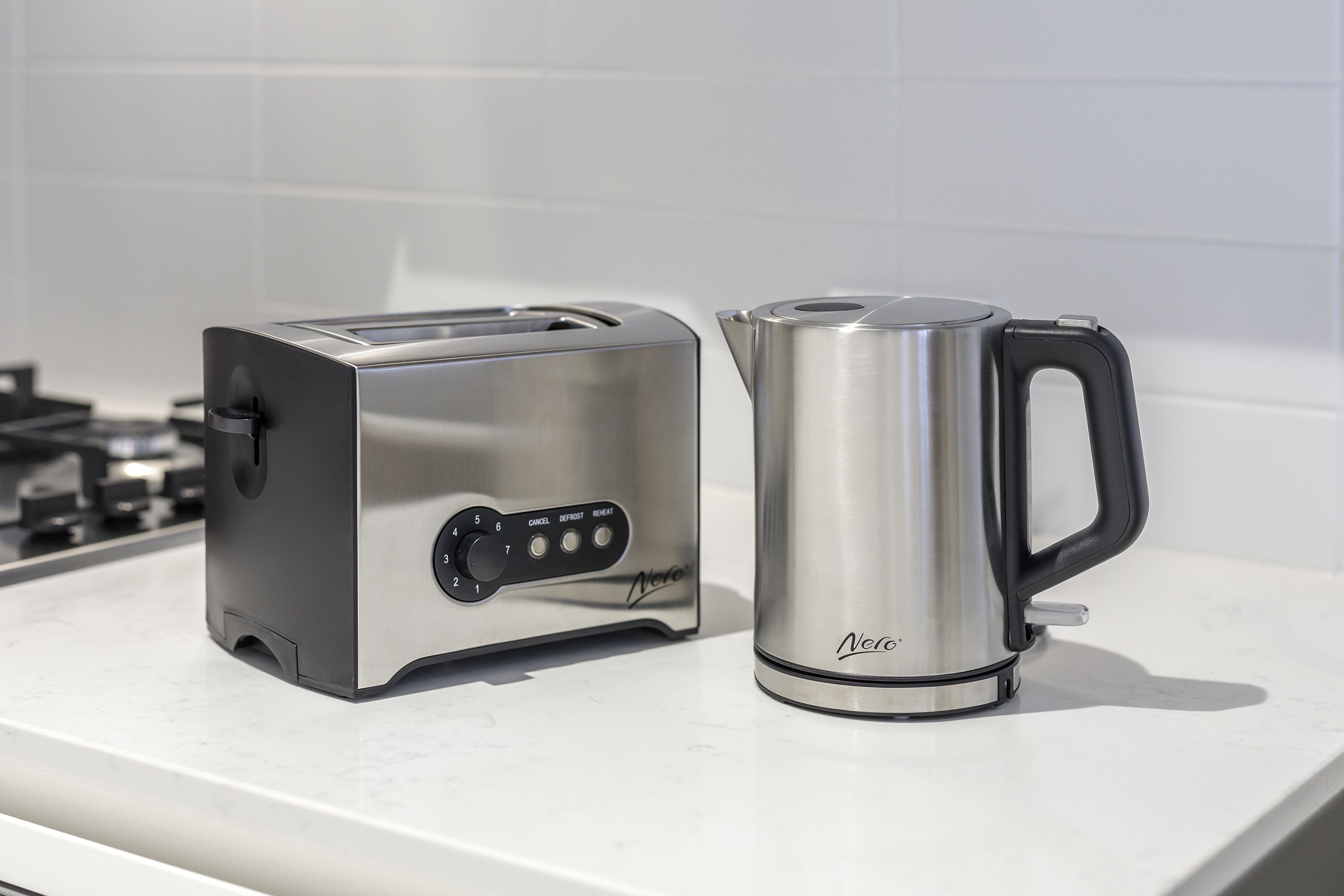 A kitchen counter with a toaster and a kettle.