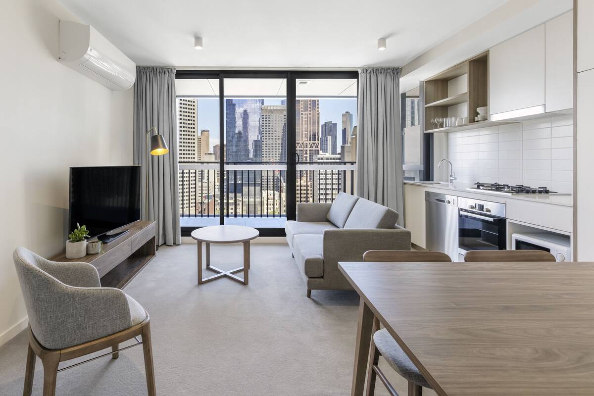 Un apartamento moderno con balcón, comedor, sala de estar y cocina.
