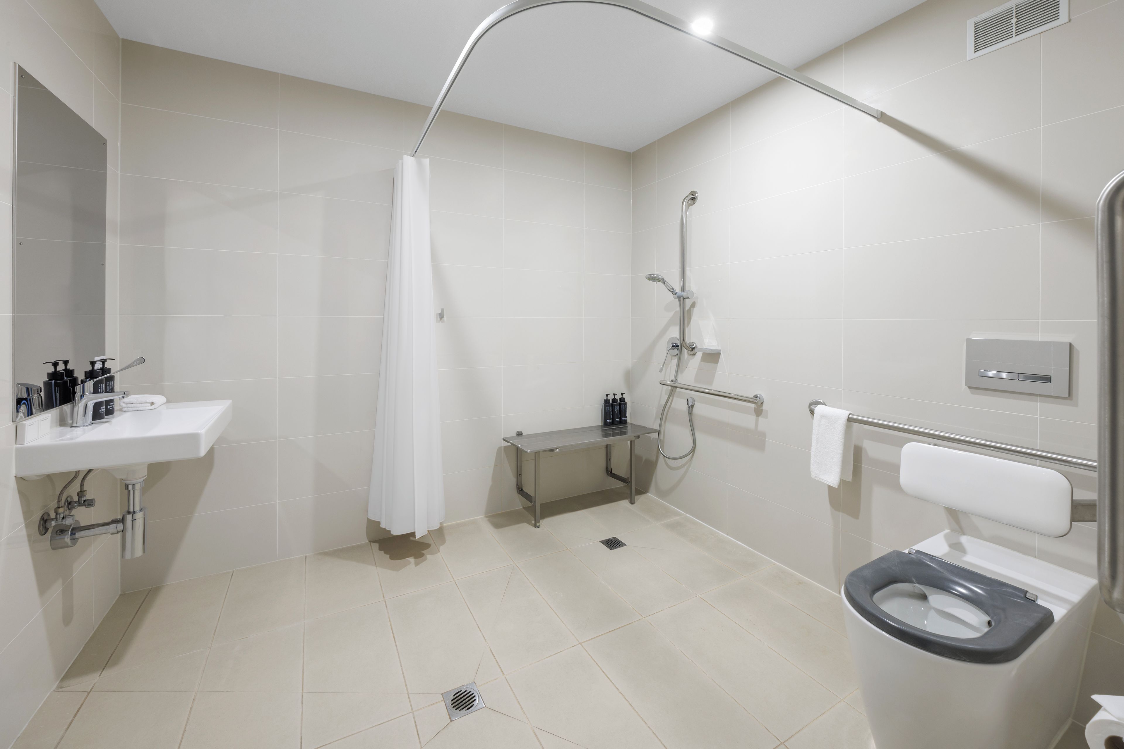 A modern bathroom with a shower, toilet, and sink.