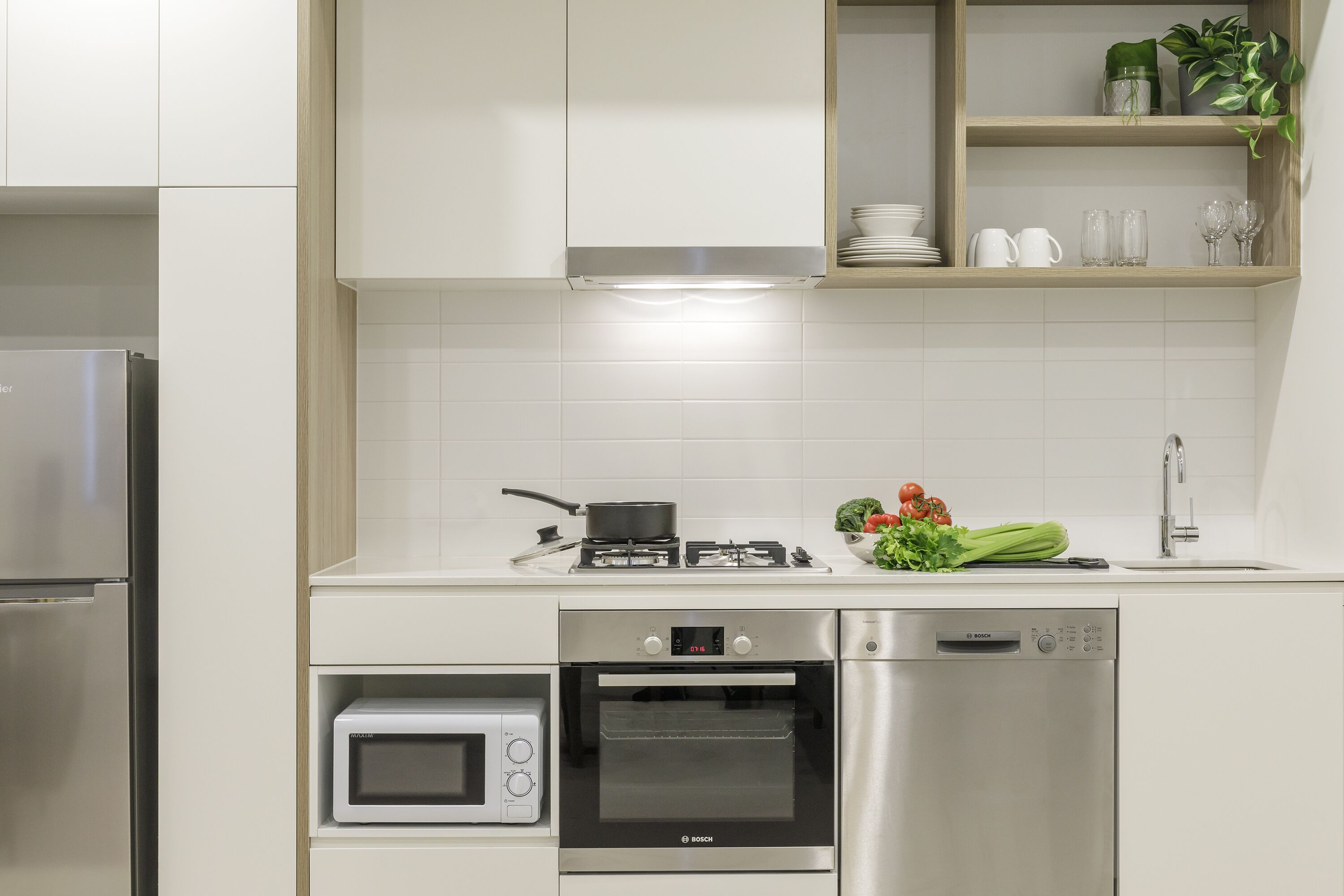 Una cocina moderna con horno empotrado, microondas y lavavajillas.