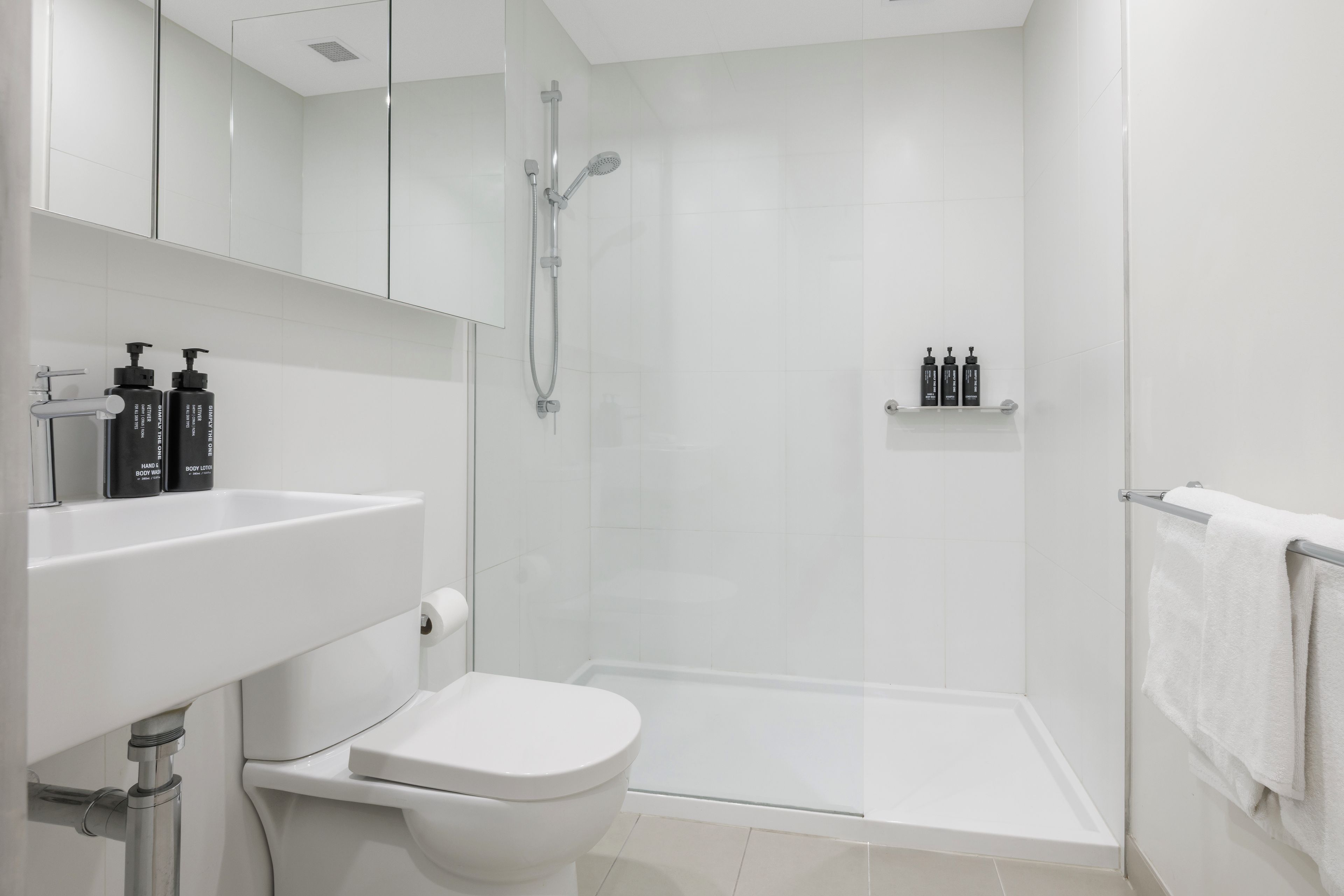 Et stilfuldt badeværelse med toilet, håndvask og bruser.