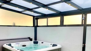 A hot tub under a glass enclosure with a green artificial turf floor. - LAS GAVIOTAS 9B APARTMENT (Tarifa)