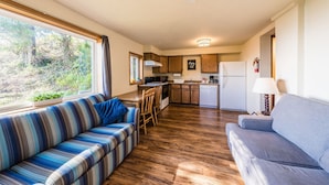 A compact living space with a sofa, a dining table, and a kitchenette.