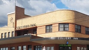 A two-story building with a sign reading "Colliery Inn." It features a brick facade, multiple windows, and a clock on the side. - Colliery Inn, Wallsend (Wallsend)