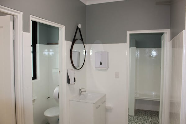 A bathroom with a toilet, sink, and shower. - Colliery Inn, Wallsend (Wallsend)