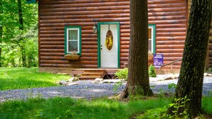 A log cabin with a green door, a bench outside, and a sign indicating it's James Madison's. - Cabin By The Creek! Inground Pool! Spa! (Dayton)