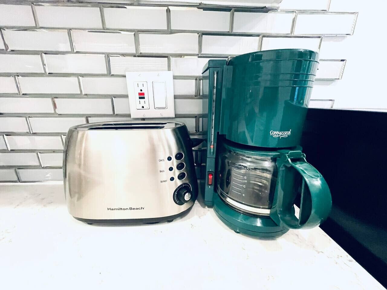 Un tostapane Hamilton Beach e una macchina da caffè Connaisseur su un bancone della cucina.