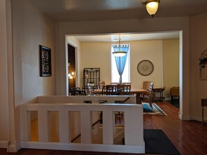 A dining area with a wooden table and chairs, a chandelier, and a decorative wall piece. - Broadway Loft (Springfield)