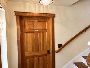 A wooden door with a sign indicating 'MT ADAIR ROOM' and a modern light fixture above it.