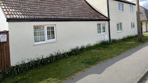 A two-story house with a tiled roof, white exterior walls, and multiple windows. - Rain Hill Cottage - Sleeps 4, Parking & Pets Ok (Louth)
