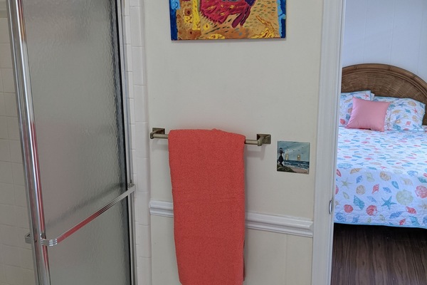 Een bad/douchecombinatie, handdoeken, zeep, toiletpapier