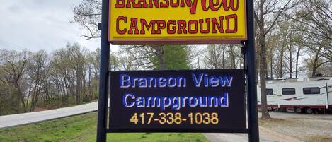 A campground sign with the name 'Branson View Campground' and a phone number.