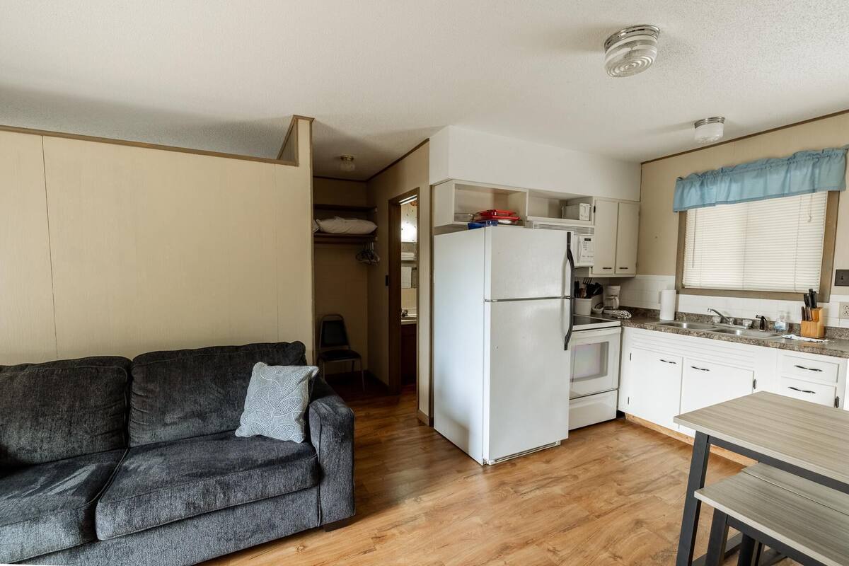 A compact living space with a kitchenette, a sofa, and a dining table.