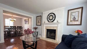 Ein Wohnzimmer mit Kamin, Essbereich und einer Couch.