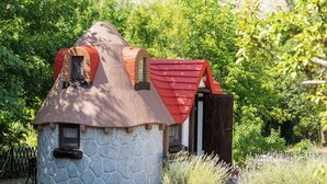 A small, stone cottage with a red roof and a wooden door, surrounded by greenery. - Little Castle by Interhome (Skradin)