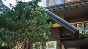 A two-story building with a wooden staircase leading to the entrance. - Whistler Village Townhome (Whistler)