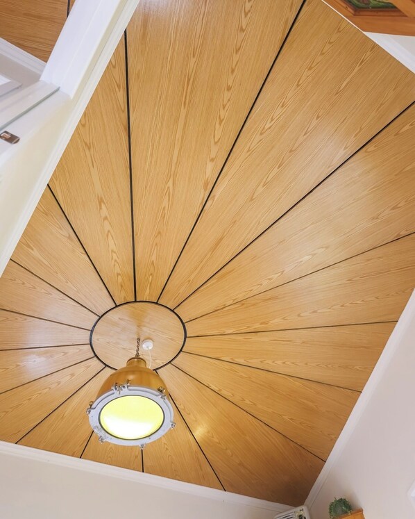A wooden ceiling with a central light fixture.