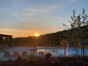 A poolside area with lounge chairs and a gazebo, surrounded by a landscaped garden with rocks and plants. - Journey's Remedy (Branson)