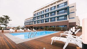 Una piscina con sillones de descanso y una terraza de madera.