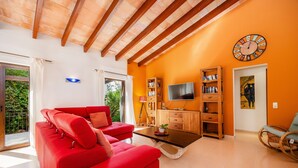 A modern living room with a red sofa, wooden coffee table, and a television.