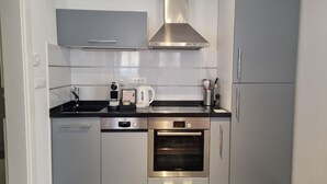Eine moderne Küche mit Edelstahlgeräten, einem Backofen und einer Kaffeemaschine.