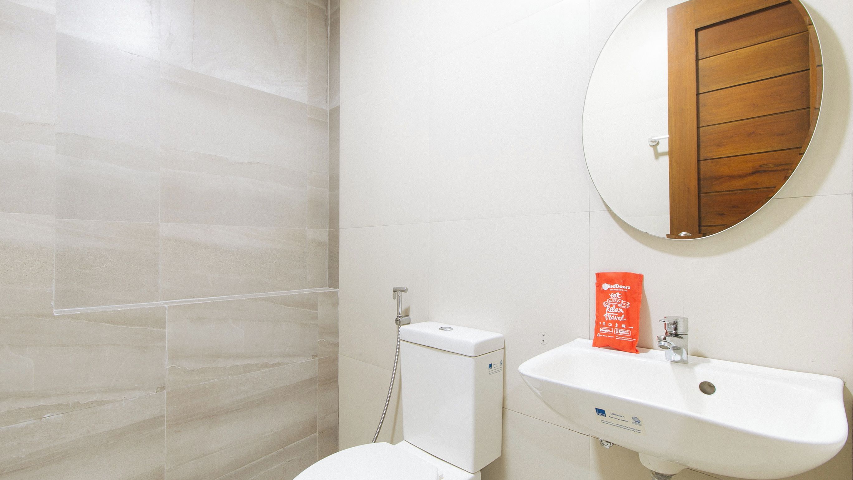 A bathroom with a toilet, a sink, and a mirror.