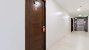 A hotel corridor with a wooden door labeled '2nd Floor' and an elevator in the distance.