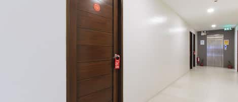 A hotel corridor with a wooden door labeled '2nd Floor' and an elevator in the distance.