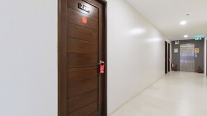 A hotel corridor with a wooden door labeled '2nd Floor' and an elevator in the distance. - Reddoorz Near Fernwoods Garden Quezon City (Quezon City)