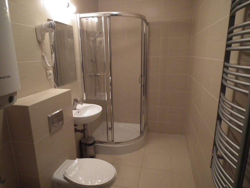 Een badkamer met toilet, wastafel en douchecabine.
