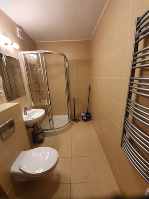 A bathroom with a shower, two sinks, a toilet, and a towel rack. - LIDO Apartamenty (Sarbinowo)