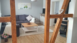 A cozy living room with a sofa, a wooden coffee table, and a white rug.