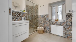 A bathroom with a shower, a sink, a toilet, and a window. - GuestHost - Cozy 60 sqm apartment, for 3 people, with 3 balconies and located on the 2nd floor of a renovated building without lift. The property is located in the heart of the historic center (Traffic Restricted Area), inside Vucciria area, one of the c (Palermo)