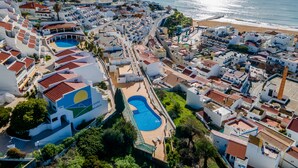 Een kustresort met diverse zwembaden, een strand en een combinatie van moderne en traditionele architectuur.