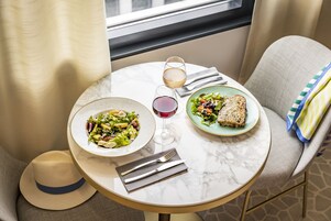 Una mesa de comedor con dos platos de comida, copas de vino y cubiertos.