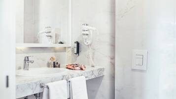 A modern bathroom with a marble sink, a toilet, and a mirror.