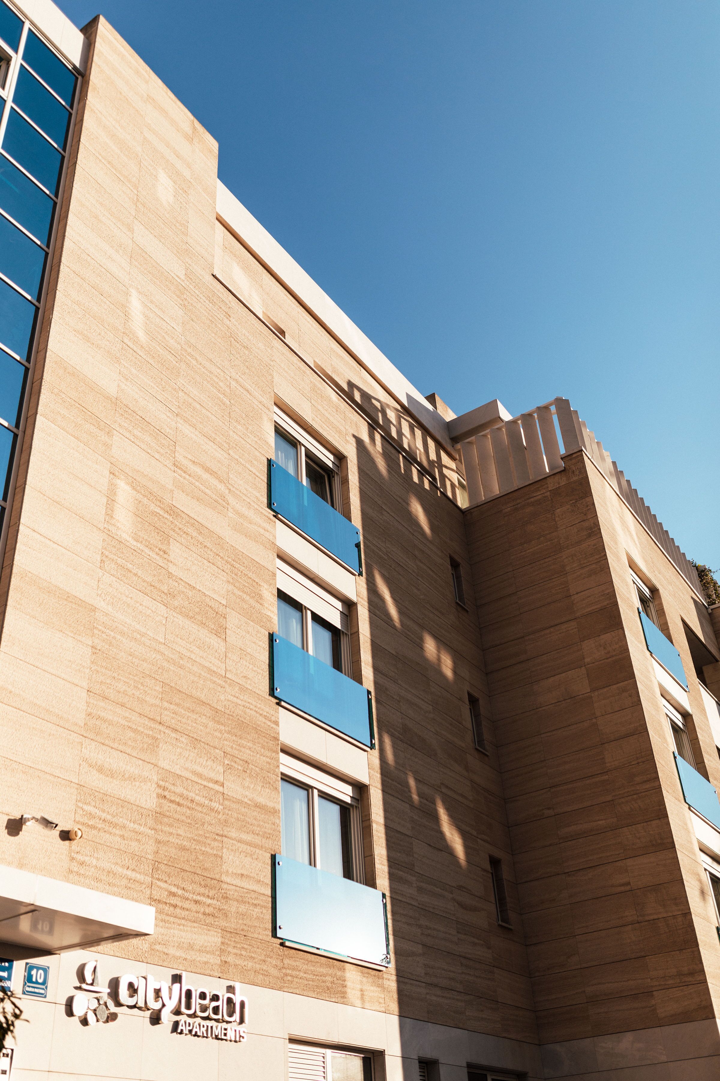 Un edificio con un diseño arquitectónico moderno, que destaca por su entrada principal y numerosos ventanales.