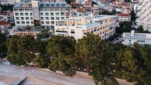 A hotel with multiple floors, balconies, and a beach view.