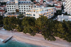A hotel with multiple floors, balconies, and a beach view. - City Beach Apartments Makarska (Makarska)